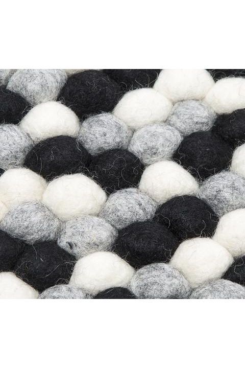 Sort og hvidt håndlavet kugletæppe af 100% ren uld tilføjer hygge og stil. Blødt uld materiale og enestående design. Perfekt til at skabe en varm atmosfære i dit hjem.