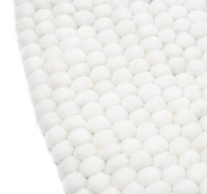 Hvidt håndlavet kugletæppe af 100% ren uld tilføjer hygge og stil. Blødt uld materiale og enestående design. Perfekt til at skabe en varm atmosfære i dit hjem.