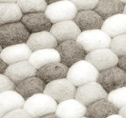 Gråt og hvidt håndlavet kugletæppe af 100% ren uld tilføjer hygge og stil. Blødt uld materiale og enestående design. Perfekt til at skabe en varm atmosfære i dit hjem.