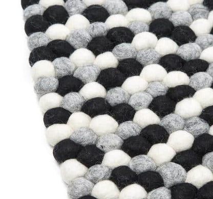 Sort og hvidt håndlavet kugletæppe af 100% ren uld tilføjer hygge og stil. Blødt uld materiale og enestående design. Perfekt til at skabe en varm atmosfære i dit hjem.
