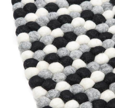 Sort og hvidt håndlavet kugletæppe af 100% ren uld tilføjer hygge og stil. Blødt uld materiale og enestående design. Perfekt til at skabe en varm atmosfære i dit hjem.