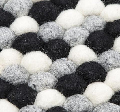 Sort og hvidt håndlavet kugletæppe af 100% ren uld tilføjer hygge og stil. Blødt uld materiale og enestående design. Perfekt til at skabe en varm atmosfære i dit hjem.
