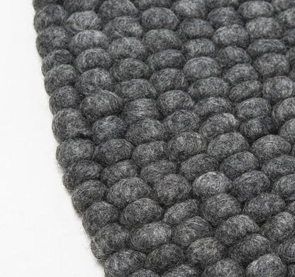 Håndlavede kugletæpper af 100% ren uld tilføjer hygge og stil. Blødt uld materiale og enestående design. Perfekt til at skabe en varm atmosfære i dit hjem.